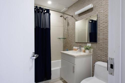 La salle de bains est pourvue d'un lavabo, de toilettes et d'un miroir. dans l'établissement 809-5A Gorgeous New 1BR Heart of Midtown, à New York