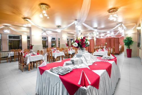 Hotel Monttis في سوخا بدسيسكا: غرفة طعام مع طاولات وكراسي حمراء وبيضاء