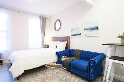 1 dormitorio con 1 cama y 1 sofá azul en 240-5 NEW Prime Location STUDIO W&D in unit, en Nueva York