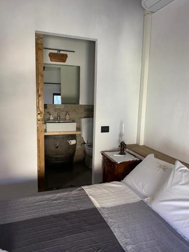 Locanda Tarello1880 في Roppolo: غرفة نوم بسرير وحمام مع حوض