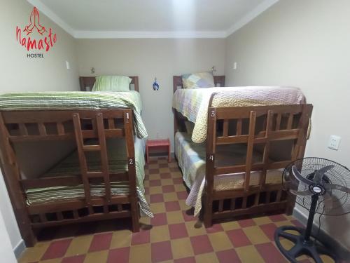 a bedroom with two bunk beds and a fan at Namaste Hostel in Tarija