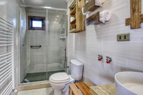 uma casa de banho com um WC, um chuveiro e um lavatório. em Cabañas Natales Rotundo em Puerto Natales