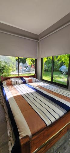 Cama grande en habitación con ventana grande en Monoambiente en casa familiar en Mar de Ajó