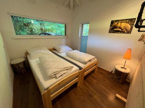 a bedroom with a bed in a room with a window at Zauberhaftes Waldhaus in Blaubeuren
