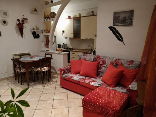 ein Wohnzimmer mit einem roten Sofa und einem Tisch in der Unterkunft Rosaspina in Grosseto