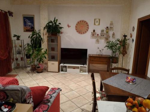 ein Wohnzimmer mit einem Flachbild-TV und einem Tisch in der Unterkunft Rosaspina in Grosseto