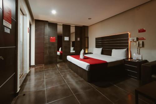 a bedroom with a large bed with a red blanket at Auto Hotel Las Maravillas in Santa Cruz Xoxocotlán