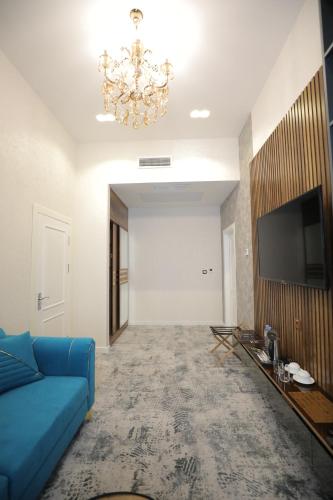 a living room with a blue couch and a television at MaxWell Hotel & SPA in Tashkent
