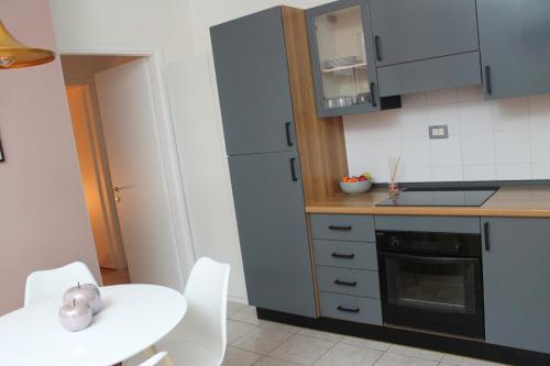 - une cuisine avec une table et une table et des chaises blanches dans l'établissement Appartamento Perini, à Trente