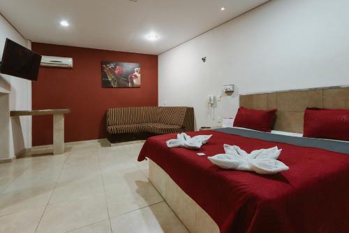 um quarto com uma cama vermelha e 2 toalhas brancas em Auto Hotel Las Maravillas em Santa Cruz Xoxocotlán