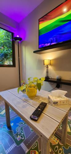 sala de estar con mesa y TV en la pared en Monoambiente en casa familiar en Mar de Ajó