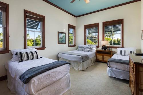 a bedroom with three beds and a table and windows at Hilton Pool Pass Included, Kolea - Luxe Penthouse in Waikoloa