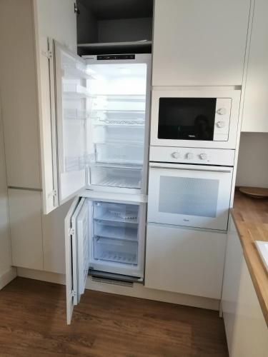 an empty refrigerator with its door open in a kitchen at Villa Frescura do Mar by Casas de Setúbal in Setúbal