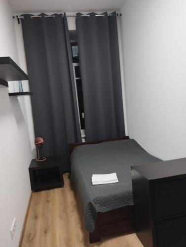 a bedroom with a bed and a window with black curtains at Centro Hostel in Vilnius
