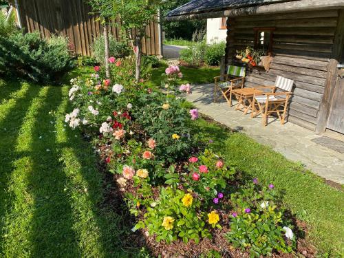 a garden with flowers in front of a cabin at Oberleiten Apartments in Wagrain