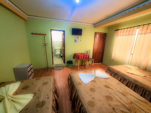 a room with two beds in a room at HOSTAL Luz YHOBIMAR in Copacabana