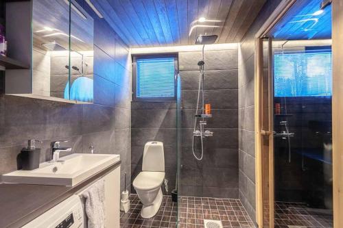 La salle de bains est pourvue d'une douche, d'un lavabo et de toilettes. dans l'établissement Chalet Ellivuori huoneisto as 1, à Sastamala