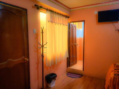 a room with a mirror and a curtain and a door at HOSTAL Luz YHOBIMAR in Copacabana