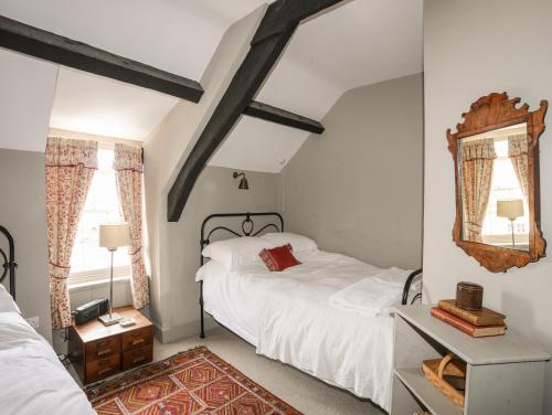 1 dormitorio con 2 camas y espejo en Bryn Tegid, en Beaumaris