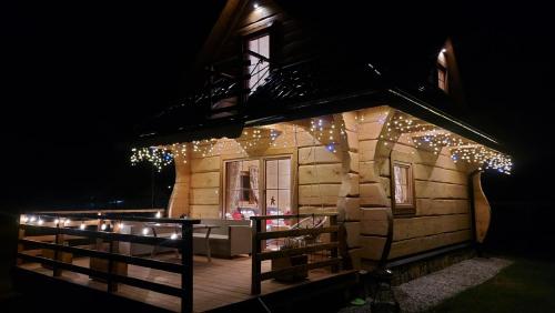 a house with christmas lights on the side of it at Słoneczna Chata z Bali in Lądek-Zdrój