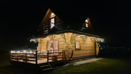 a cabin with christmas lights on it at night at Słoneczna Chata z Bali in Lądek-Zdrój