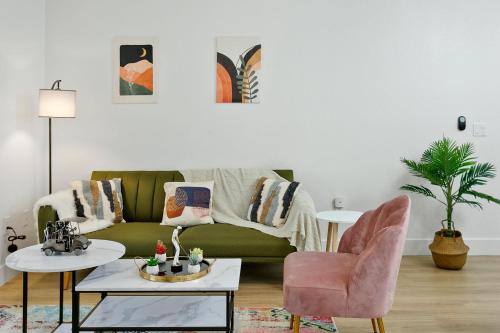 a living room with a green couch and a pink chair at CozySuites Glendale by the stadium w pool 07 in Glendale