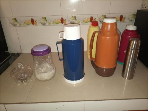 a counter top with bottles and condiments on it at Pearl Furnished Rooms Buloba in Kampala