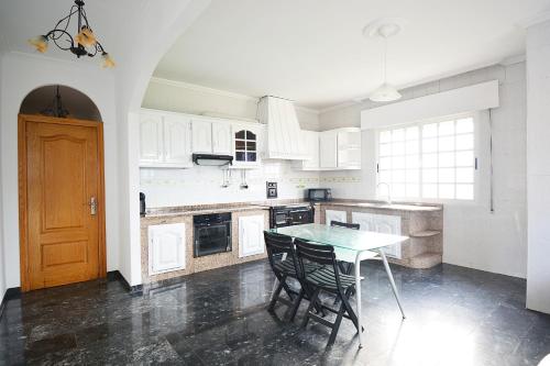 una cocina con mesa y sillas. en Apartamento da Pedra e da Auga en Meis