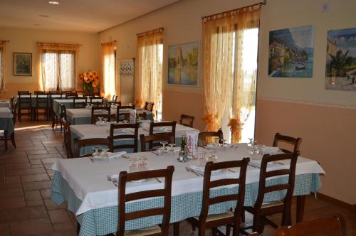 un comedor con mesas, sillas y ventanas en Agriturismo Ca' Del Gal, en Valeggio sul Mincio