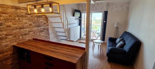 a living room with a couch and a stair case at Studio vue sur mer in La Chaume