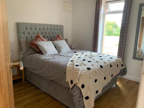 a bedroom with a large bed with a large window at The Garden Room - Nature Stay in Suckley