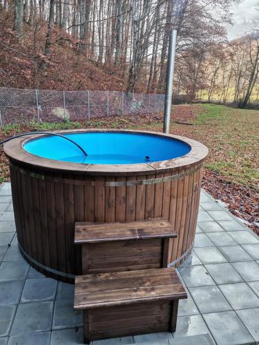 a wooden jacuzzi tub with a bench around it at Fontana erdélyi vendégház in Odorheiu Secuiesc