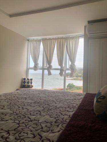 1 dormitorio con 1 cama grande y ventana grande en Oceana, en Portmore