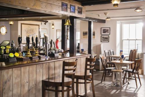 a bar in a restaurant with chairs and tables at The Old Success Inn in Sennen Cove