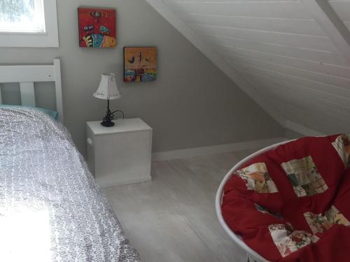 a bedroom with a bed and a chair next to a table at Cozy ,artistic cottage in a garden setting close to the beach and hiking trails. in Powell River