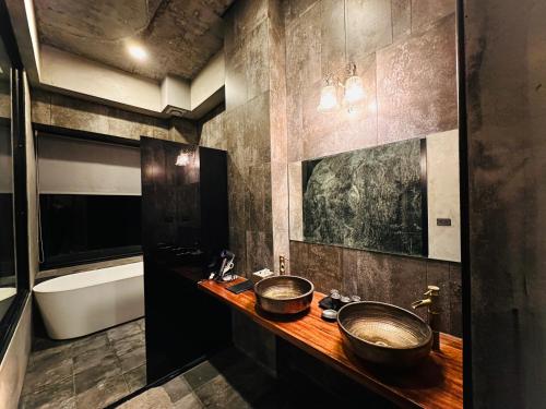 a bathroom with two sinks and a tub at Zephyr Homestay in Yanliau