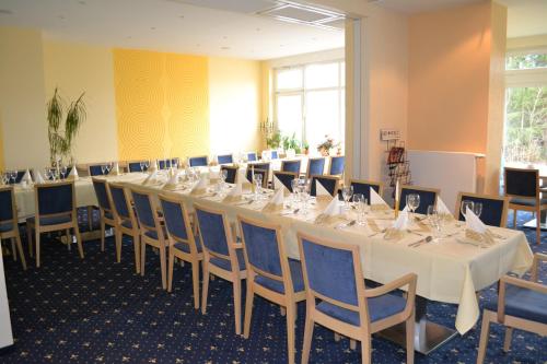 uma sala de conferências com uma mesa longa e cadeiras em City-Hotel Cottbus em Cottbus