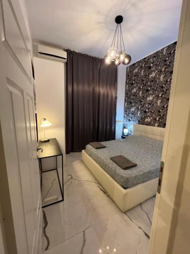 - une chambre avec un lit et un lustre dans l'établissement Casa Lorenzo, à Rome