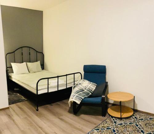 1 dormitorio con 1 cama, 1 silla y 1 mesa en Luhtikadun Studio Apartment en Lahti