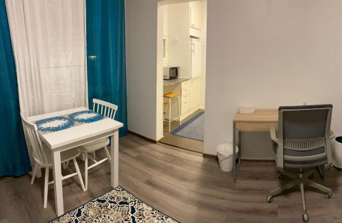 um pequeno quarto com uma mesa, uma secretária e uma cadeira em Luhtikadun Studio Apartment em Lahti