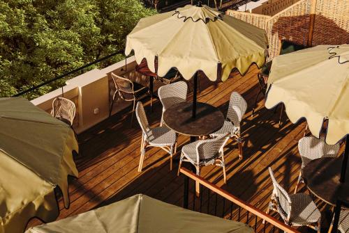 a deck with a table and chairs and umbrellas at Sonder Casa Luz in Barcelona