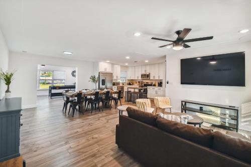 a living room with a couch and a dining room at Plush sheets, Games!, Huge backyard, Massage Chair in Tampa