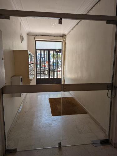 une pièce vide avec une porte en verre et une fenêtre dans l'établissement ROSE, à Saint-Mandé