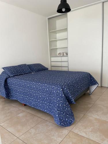 1 dormitorio con 1 cama con edredón azul en Hermoso Departamento Tipo Loft -Mendoza en Godoy Cruz
