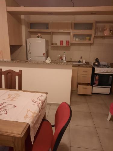 una cocina con mesa, 2 sillas y mesa y una cocina con en Lindo departamento en Córdoba