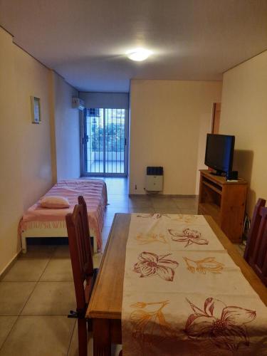 Habitación con mesa, cama y TV. en Lindo departamento en Córdoba