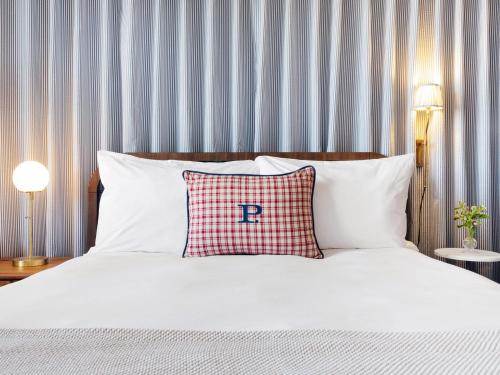 a bed with a pillow with the letter r on it at Palihotel San Diego Gaslamp Quarter in San Diego