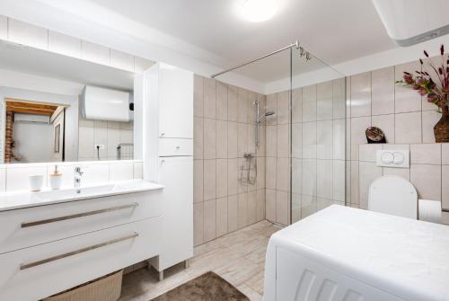 a white bathroom with a shower and a sink at Apartment VOLTE in Punat