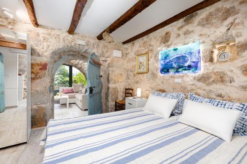 a bedroom with a large bed in a stone wall at Apartment VOLTE in Punat