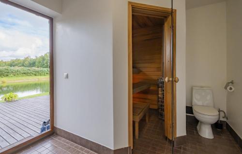 a bathroom with a toilet and a view of a river at Ninnujärve Private Holiday Home in Nasva